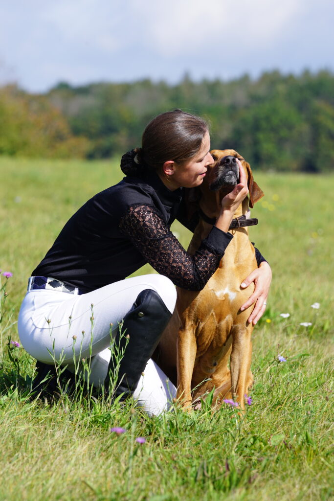 Frau mit ihrem Hund bei einem natürlichen Hundefotoshooting im Freien