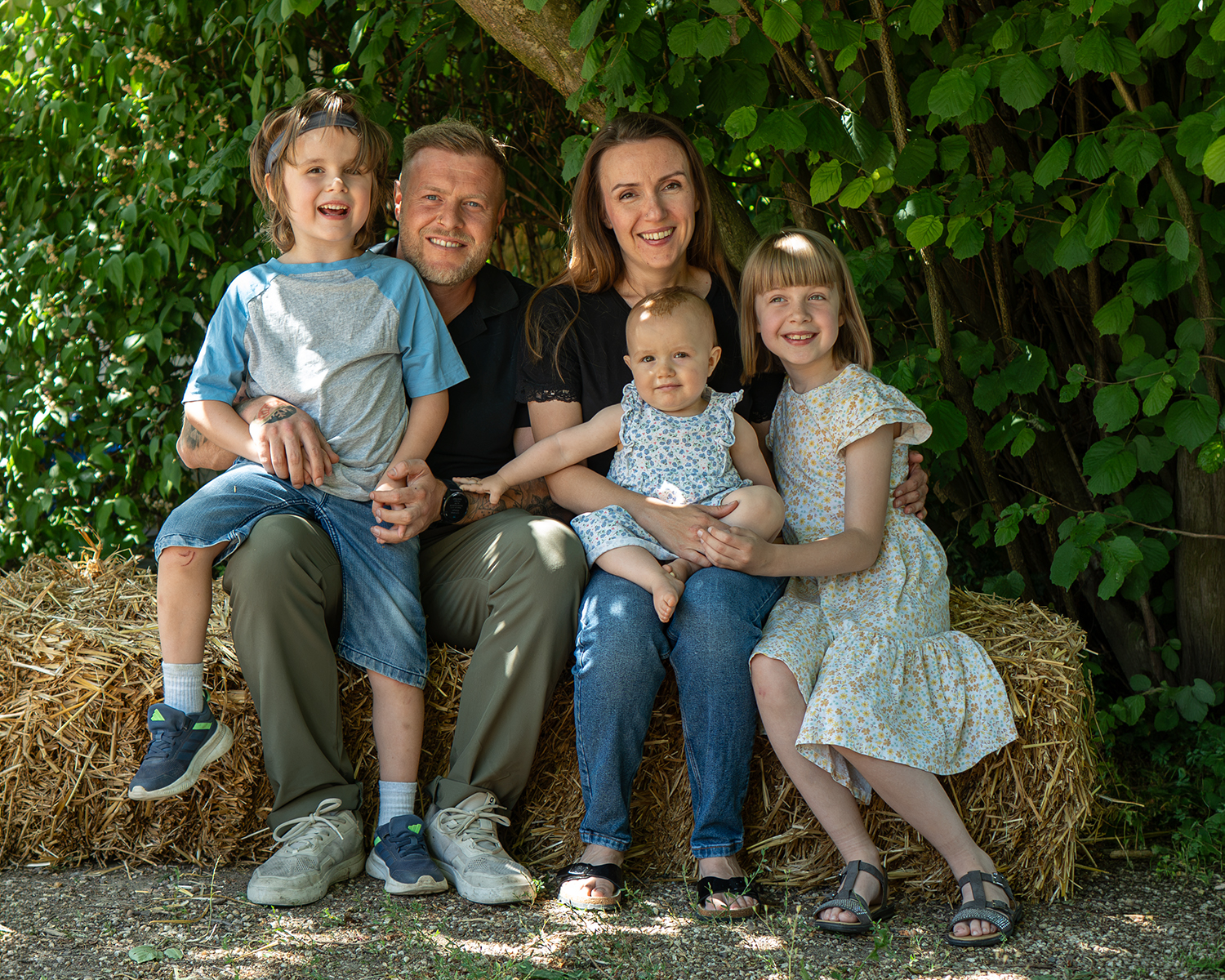 Familie mit Kindern bei einem natürlichen Familienshooting im Freien